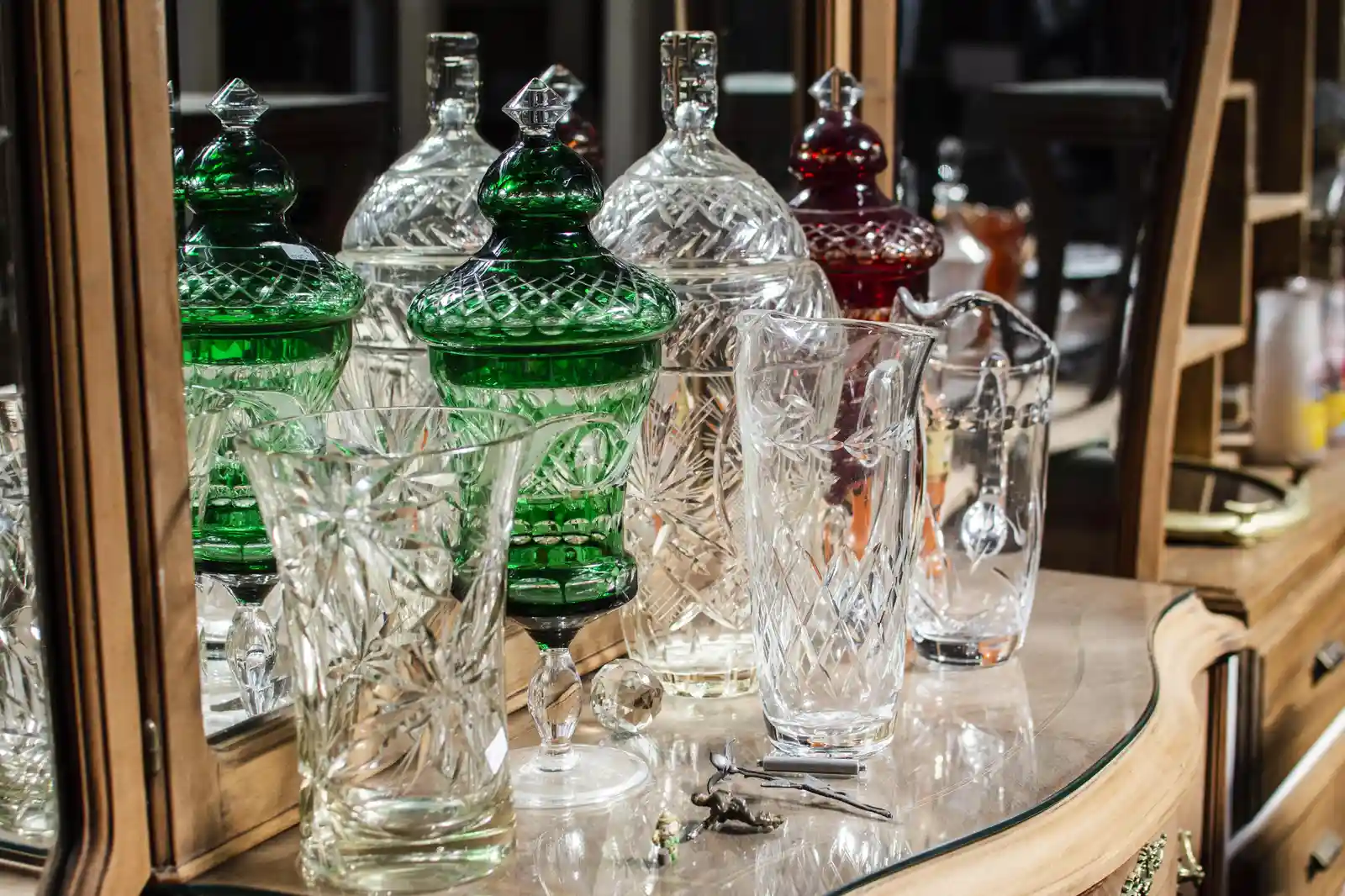 Vintage green, red, and clear glassware displayed at an antique market